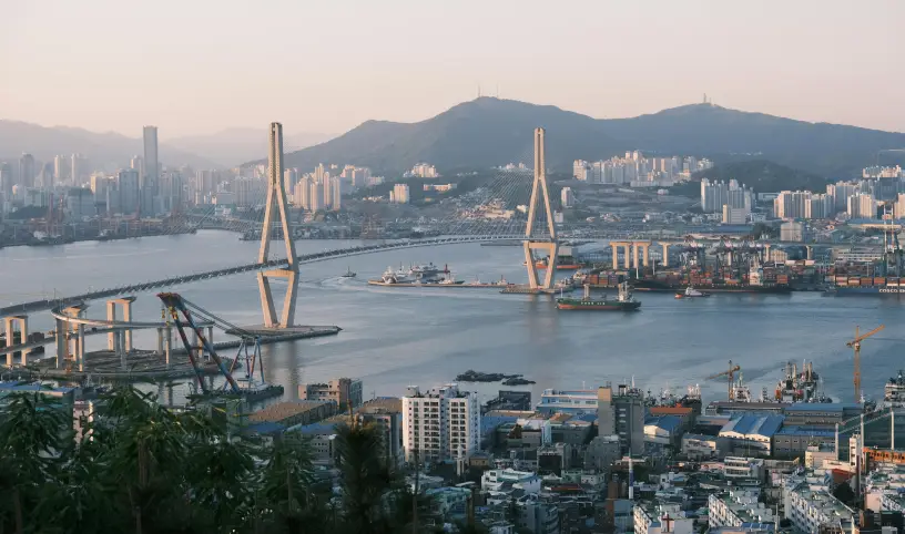 Autor/ka fotografie: chanho choi: https://www.pexels.com/cs-cz/foto/panoramaticky-vyhled-na-pusan-s-ikonickym-mostem-32155352/;