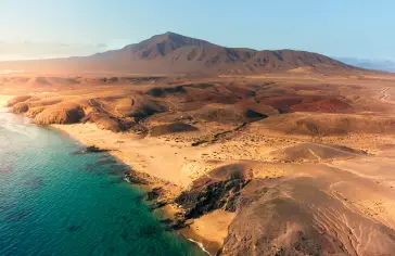 Photo by <a href="https://unsplash.com/@ionutdobre?utm_content=creditCopyText&utm_medium=referral&utm_source=unsplash">ionut dobre</a> on <a href="https://unsplash.com/photos/an-aerial-view-of-a-beach-and-mountains-jEkgqhl8tKE?utm_content=creditCopyText&utm_medium=referral&utm_source=unsplash">Unsplash</a>;