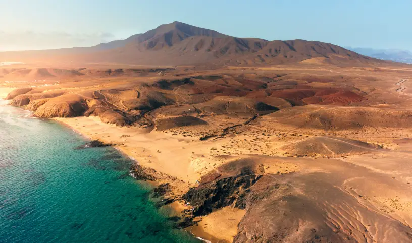 Photo by <a href="https://unsplash.com/@ionutdobre?utm_content=creditCopyText&utm_medium=referral&utm_source=unsplash">ionut dobre</a> on <a href="https://unsplash.com/photos/an-aerial-view-of-a-beach-and-mountains-jEkgqhl8tKE?utm_content=creditCopyText&utm_medium=referral&utm_source=unsplash">Unsplash</a>;